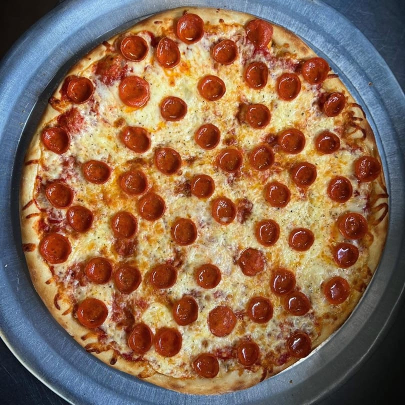 A whole pepperoni pizza from Genovas Italian Restaurant & Pizza, with melted cheese and a crispy crust.
