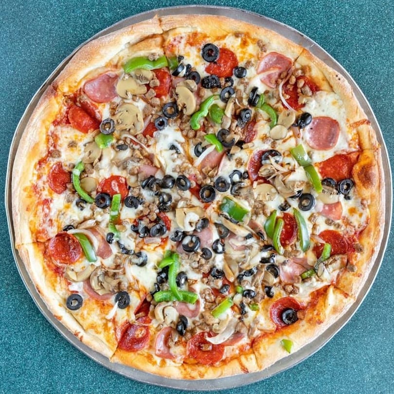 A large Genova's Italian Restaurant pizza with pepperoni, sausage, mushrooms, olives, and green peppers.